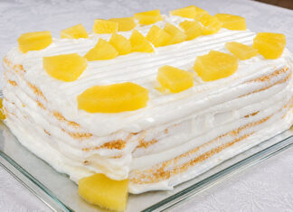 Fica uma perdição o Bolo de Ananás caseiro da avó Palmira Bolo de Ananás caseiro da Avó Palmira, muito fofo e húmido, coberto com creme branco e pedaços de ananás, servido numa travessa de vidro, perfeito para sobremesas e lanches em família.